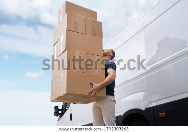 Movers Carrying\
Heavy Large Box Stack Near\
Truck
