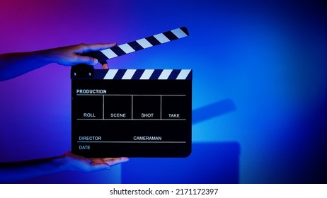 Movie Clapper Board. Crew Hand Holding Plastic And Wooden Film Slate Board Against Camera. Movie Clapperboard Using In Video Production And Movie Studio Works Film Industry. Film Slate On Crew Hand.