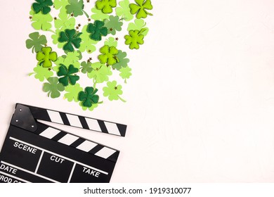 Movie Clapper Board With Decorative Clover Leaves And Gold Stars On White Background With Copy Space. Saint Patrick's Day Movies Concept.