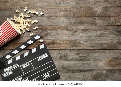 Filmklapper und Popcorn auf Holzhintergrund, Draufsicht