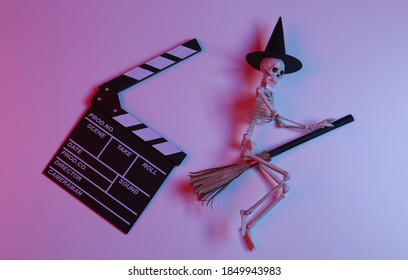 Movie clapperboard with witch skeleton on broomstick in gradient neon red-blue light. Halloween scary movie - Powered by Shutterstock