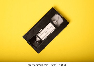 Movie Night - Video Tape on Yellow Background. VHS Tape, a staple of an age before streaming, when movie rental stores were a necessary element of watching a movie at home.