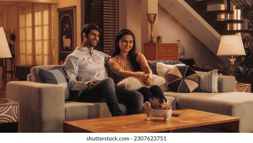 Movie Night: Young Couple Relaxing on the Couch, Watching Exciting Movie on TV. Girlfriend and Boyfriend Embrace, Cuddle, Talk, Smile and watch Television Streaming Services in Cozy Home - Powered by Shutterstock