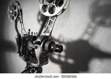 Movie Projector With The Film On The Background  Of Gray Wall