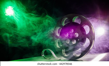 Movie Reel Of Film In Retro In The Smoke Of Green And Purple On A Dark Background