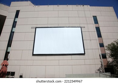 Movie Screen. An Outdoor Theater Screen Or Movie Screen Attached To A Tall Building. A Projection Screen For A Movie Or Slideshow Presentation On A Building Wall. Outdoor Presentation On A Wall.