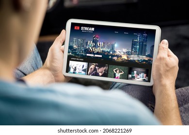 Movie and series stream VOD service in tablet. Watching on demand tv show or film online. Man choosing video entertainment from subscription media catalogue. Streaming website library mockup. - Shutterstock ID 2068221269