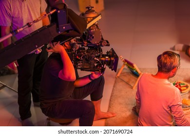 Movie shooting or video production and film crew team with camera equipment. Video camera operator working with  equipment. Director of photography with a camera in his hands on the set.