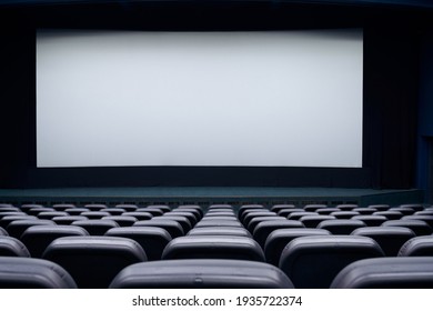 Movie Theater With Black Seats And Large Blank Screen. Concept Of Empty Cinema Hall.