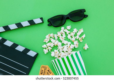  Movie Tickets, Clapperboard, Pop Corn And 3d Glasses In A Green Background.Flatlay