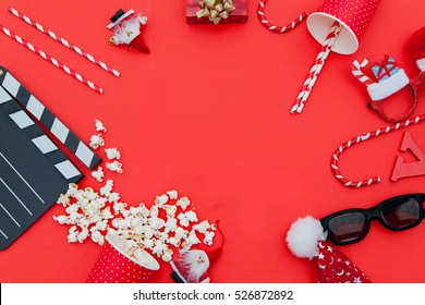 movie tickets, clapperboard, pop corn and 3d glasses in a red frame background..Flat lay .Christmas concept

