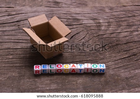 Moving to another office or house. Word relocation on an old wooden background