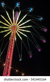 Moving Blur Image Of Merry-go-round, Chain Swing Carousel Ride In Amusement Park At Night