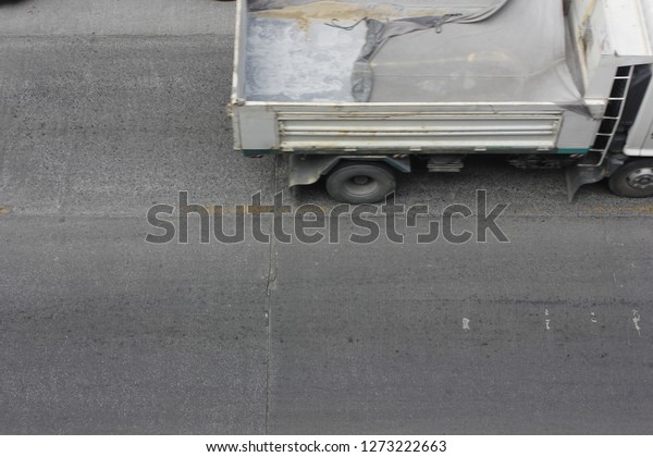 Moving\
blurred white truck on asphalt road in top\
view.