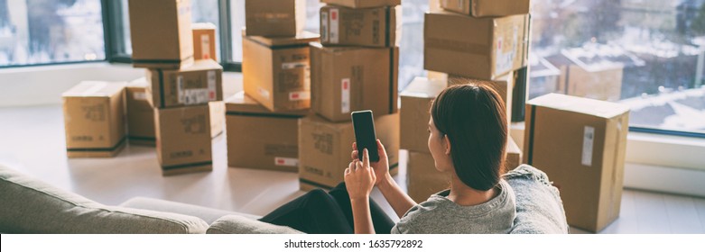 Moving Boxes Woman Using Phone Panoramic For Move To College Leaving Apartment Ready For Movers Pick-up With Packages Of Cardboard Box For New Home Move In. Banner.