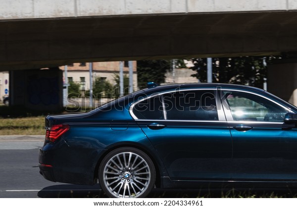 A moving car on the\
street. Side view of the back of a blue car. BMW 7 Series. Riga,\
Latvia - 04 Sep 2022.