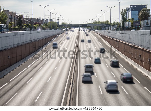 Moving cars on urban\
highway under sunlight