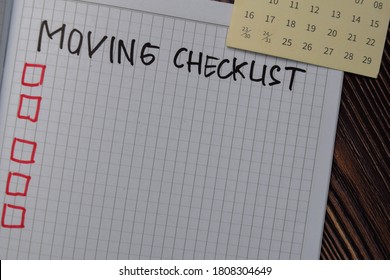 Moving Checklist write on a book. Supported by an additional services isolated on wooden table.