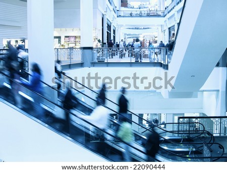 Moving crowd on escalator in modern interior
