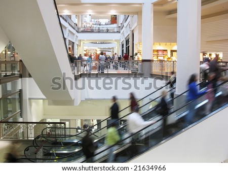 Moving crowd on escalator in shopping mall