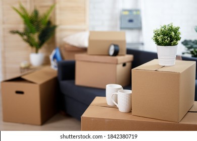 moving day concept - close up of belongings packed in cardboard boxes in living room