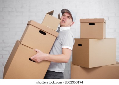 Moving Day Or Delivery Concept - Tired Deliveryman Holding Many Boxes In Hands