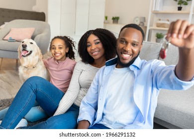 Moving Day. Happy African American family of three people and a dog holding and showing keys of their new apartment house. Excited black homeowners enjoying celebrating relocation - Powered by Shutterstock