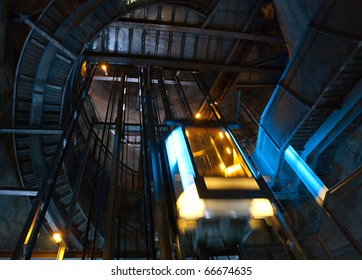 Moving elevator inside shaft with staircase.