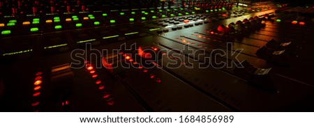 moving faders in a mixing console in a sound studio
