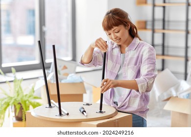 Moving, Furniture And Interior Concept - Happy Smiling Asian Woman Assembling Coffee Table At New Home