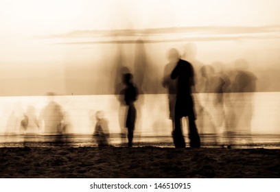 Moving Ghosts On The Beach People Walking On The Beach At Sunset. The Movement Blur Makes It Spooky. Duo Tone