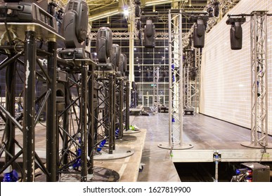 Moving head spotlight devices are clamped on a truss. Installation of professional stage, sound and light equipment for a concert. 