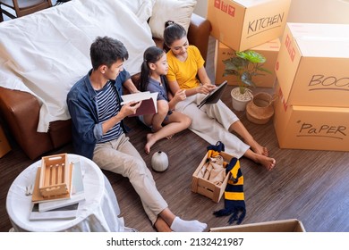 Moving Home Concept,asian Family Relax Leisure Time Sit Together With Cardboard Box And Stuff,dad Mom  Daughter Spending Time Together After Finish Packing Stuff Furniture For Home Apartment Moving 