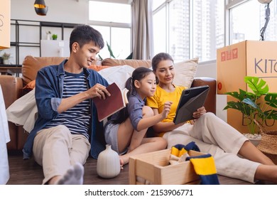 Moving Home Concept,asian Family Relax Leisure Time Sit Together With Cardboard Box And Stuff,dad Mom  Daughter Spending Time Together After Finish Packing Stuff Furniture For Home Apartment Moving 