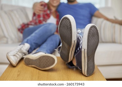 Moving, Home, Repair And People Concept - Close Up Of Couple Legs Relaxing And Sitting On Sofa With Legs On Table In New Apartment