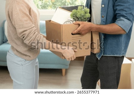 Moving house, relocation. Couple help set and move furniture for new apartment, inside the room was a cardboard box contain personal belongings. move in the new apartment or condominium