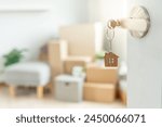 Moving house, relocation. The key was inserted into the door of the new house, inside the room was a cardboard box containing personal belongings and furniture. move in the apartment or condominium