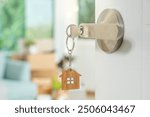 Moving house, relocation. The key was inserted into the door of the new house, inside the room was a cardboard box containing personal belongings and furniture. move in the apartment or condominium