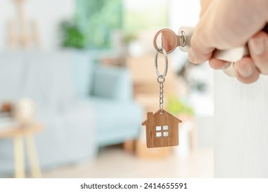 Moving house, relocation. The key was inserted into the door of the new house, inside the room was a cardboard box containing personal belongings and furniture. move in the apartment, banner - Powered by Shutterstock