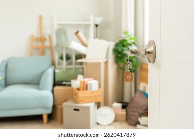 Moving house, relocation. The key was inserted into the door of the new house, inside the room was a cardboard box containing personal belongings and furniture. move in the apartment or condominium