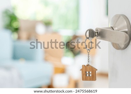 Moving house, relocation. The key was inserted into the door of the new house, inside the room was a cardboard box containing personal belongings and furniture. move in the apartment or condominium