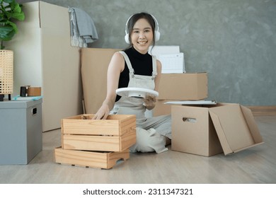 Moving house, relocation. Woman feel good and recreation on new apartment, inside the room was a cardboard box containing personal belongings and furniture. move in the house or condominium - Shutterstock ID 2311347321