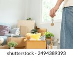 Moving house, relocation. Woman hold key house keychain in new apartment. move in new home. Buy or rent real estate. flat tenancy, leasehold property, new landlord, dwelling, loan, mortgage.
