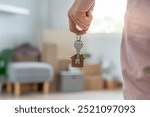 Moving house, relocation. Woman hold key house keychain in new apartment. move in new home. Buy or rent real estate. flat tenancy, leasehold property, new landlord, dwelling, loan, mortgage.
