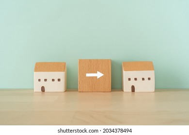 Moving house; Wooden stamps with arrow text of concept and two house toys. - Shutterstock ID 2034378494