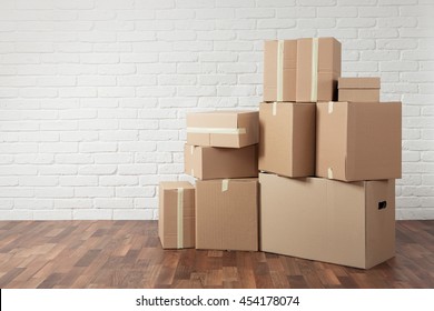 Moving in. Stack of cardboard boxes in the empty room with copy space - Shutterstock ID 454178074