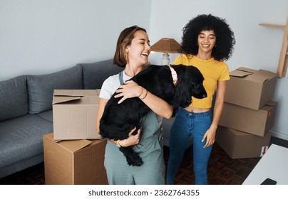 Moving, lesbian and couple with dog in new home, boxes and smile in real estate together. Property, mortgage and lgbt women with puppy in living room happy and excited for pet, love and house - Powered by Shutterstock
