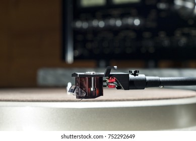 Moving magnet cartridge on the tonearm on a blurred background