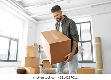 moving, people and real estate concept - happy smiling man holding boxes with stuff at new home - Shutterstock ID 2114217011