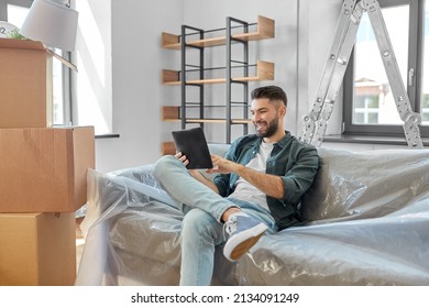 Moving, People And Real Estate Concept - Happy Smiling Man With Tablet Pc Computer And Boxes At New Home